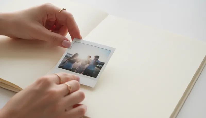 A visual representation of the Anna Kournikova Instagram strategy, showing a single, carefully chosen family photo being placed in a book, symbolizing a private life with curated public moments. anna-kournikova-instagram-strategy-bestie-ai.webp